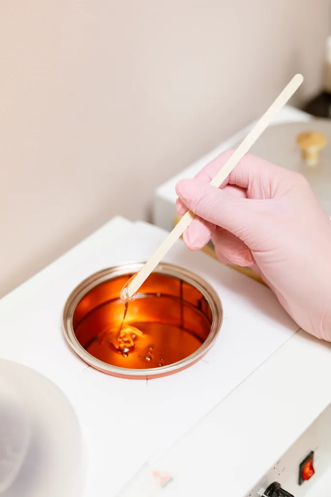 Esthetician performing leg waxing in Rochester Hills